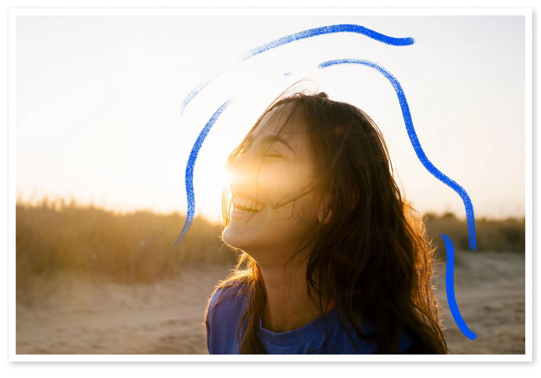 A picture of a woman laughing at sunset, being clearly happy and energetic! 