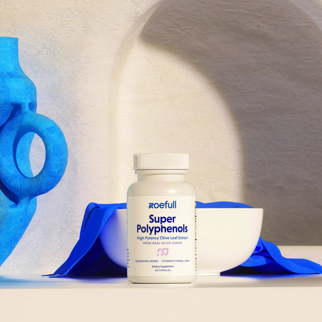 A lifestyle studio shot of zoefull's olive leaf extract in a greek cycladic setting and blue props.