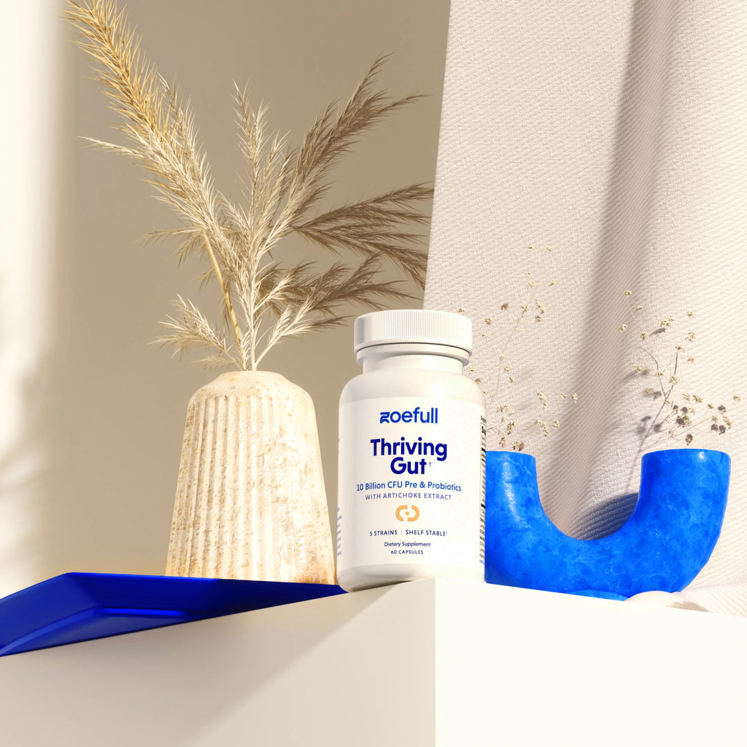 A lifestyle studio shot of zoefull's thriving gut supplement in a mediterranean setting with blue props.